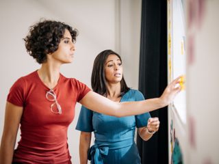 Two women talking and looking at sticky notes