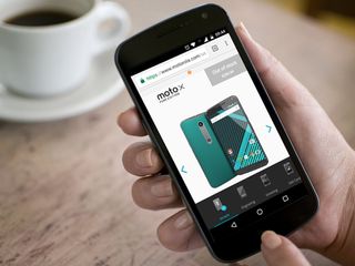 A hand holding a Motorola phone with Motorola Motomaker on the screen