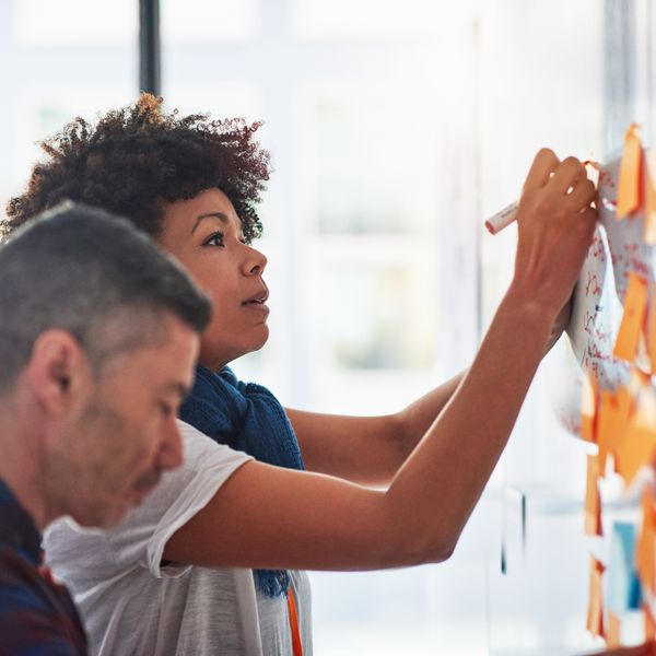 Woman and man brainstorming with sticky notes at an office