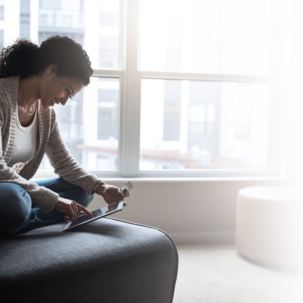 young woman relaxing on a chair while doing online browsing