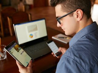 man using different devices tablet phone laptop