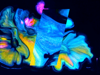 Black background with colorful paint splashed, and a glass-like inclined bar over it.