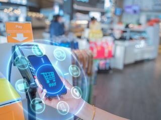 A hand holding a phone while doing mobile payment