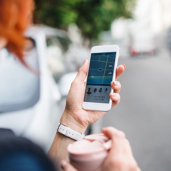 A woman looking at a ride sharing app on her phone