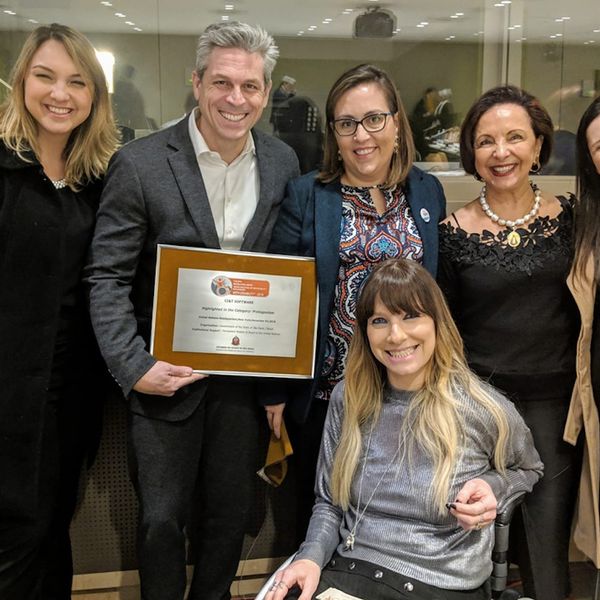 CI&T employees smiling including CI&T President Bruno Guicardi holding an award from the United Nations