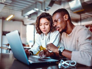 Man and woman working on a laptop
