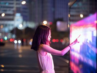 Woman using touch screen on the street