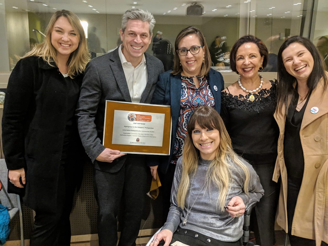CI&T employees smiling including CI&T President Bruno Guicardi holding an award from the United Nations